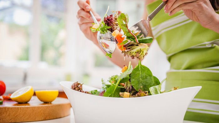 Una mujer revuelve una ensalada